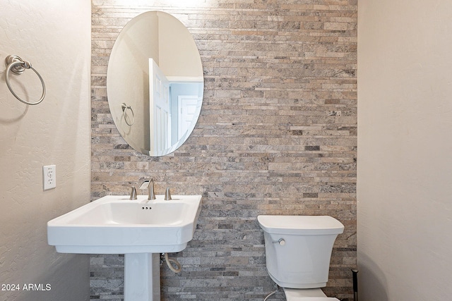 bathroom with brick wall and toilet