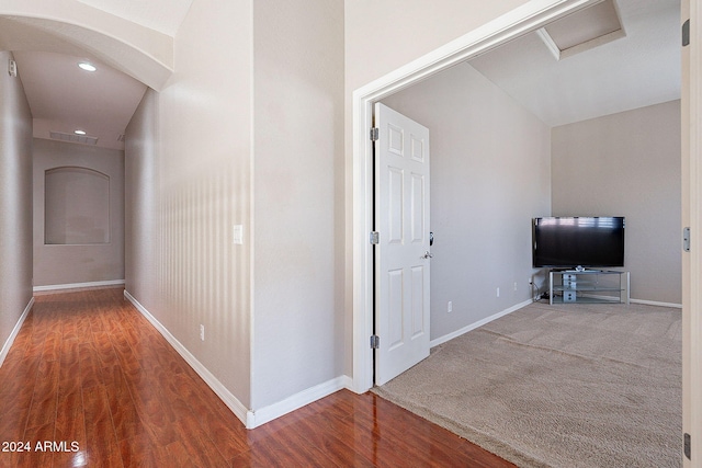 hallway with hardwood / wood-style flooring and lofted ceiling