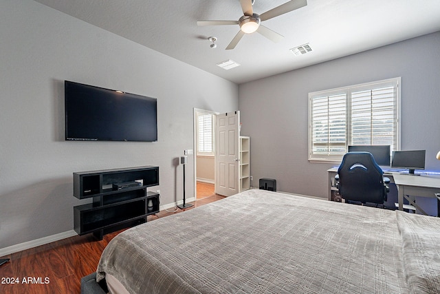 bedroom featuring dark wood-type flooring, ceiling fan, and multiple windows