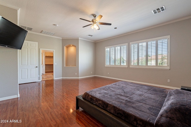 bedroom featuring dark hardwood / wood-style flooring, ceiling fan, and crown molding