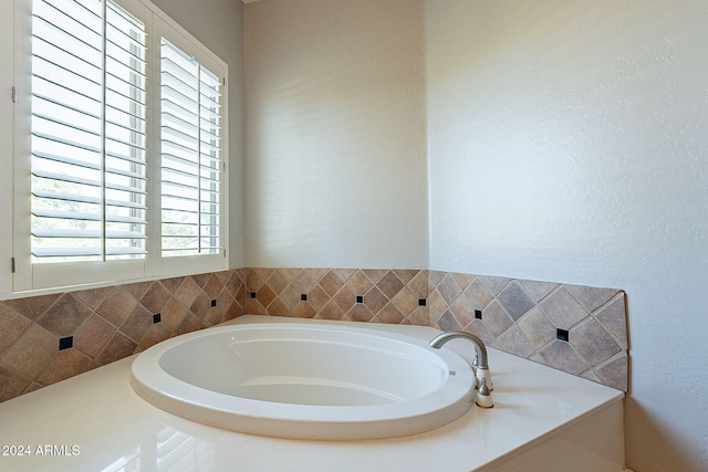 bathroom with a bathing tub and a healthy amount of sunlight