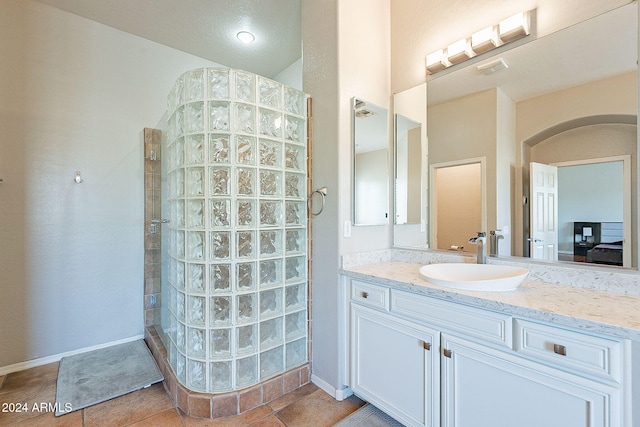 bathroom with vanity, tile patterned floors, and a tile shower