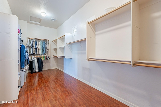 walk in closet with dark hardwood / wood-style flooring