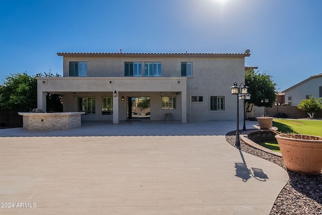 back of property with area for grilling, a lawn, and a patio area