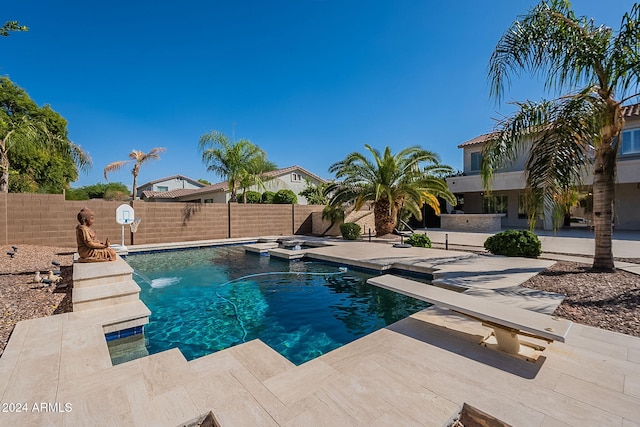 view of swimming pool with a diving board, pool water feature, and a patio area