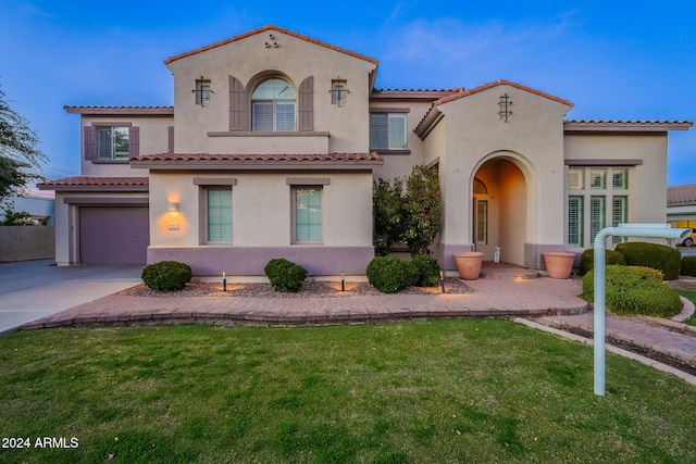 mediterranean / spanish-style house featuring a garage and a front yard