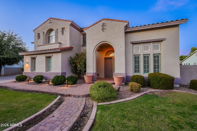 mediterranean / spanish home featuring a front lawn