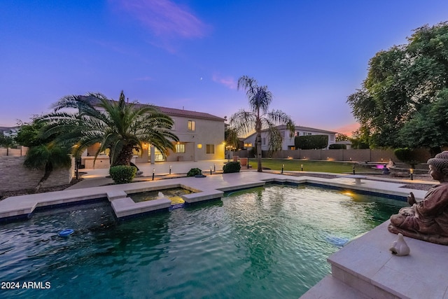 pool at dusk featuring a patio