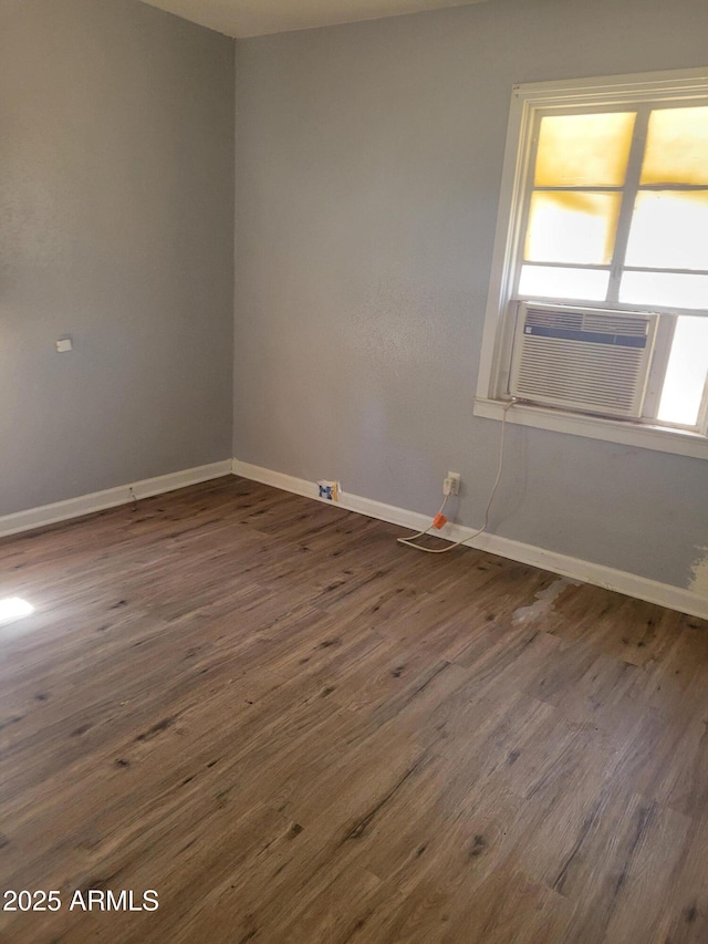 unfurnished room with dark wood-type flooring, cooling unit, and baseboards
