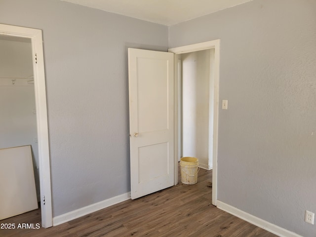unfurnished bedroom featuring baseboards and wood finished floors