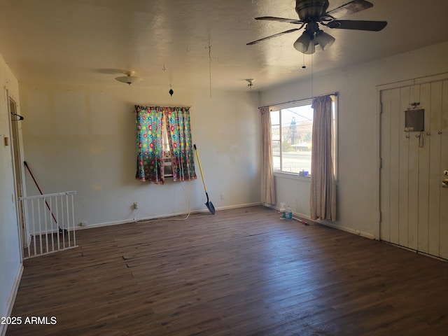 empty room featuring a ceiling fan, wood finished floors, and baseboards