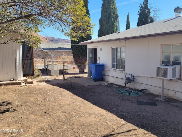 view of yard featuring cooling unit, an outdoor structure, a shed, and fence