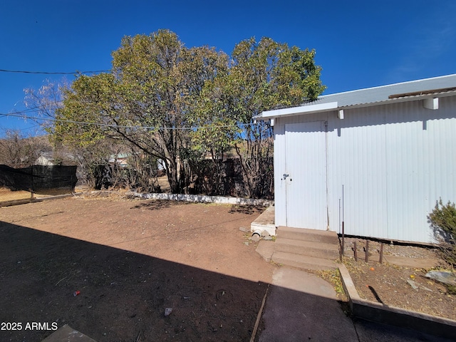 view of yard featuring fence, an outdoor structure, and entry steps