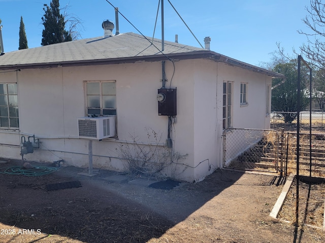 view of side of home with cooling unit and fence