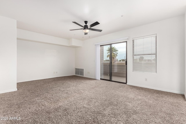 spare room featuring carpet flooring, baseboards, visible vents, and ceiling fan