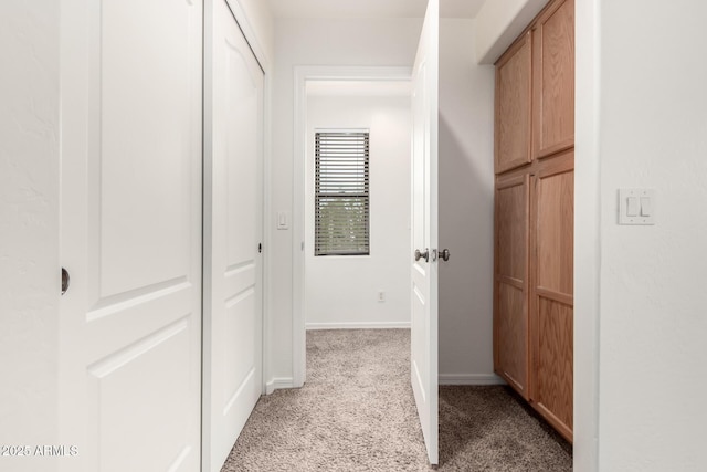 hallway with baseboards and carpet