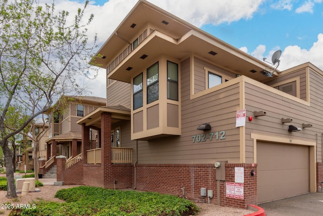 view of side of home featuring aphalt driveway and brick siding