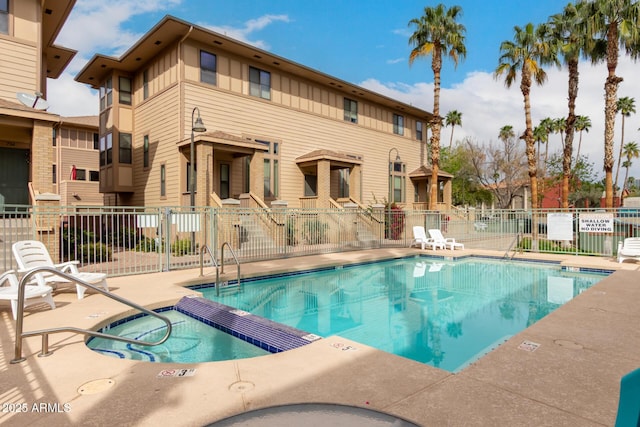 community pool with a community hot tub, a patio, and fence