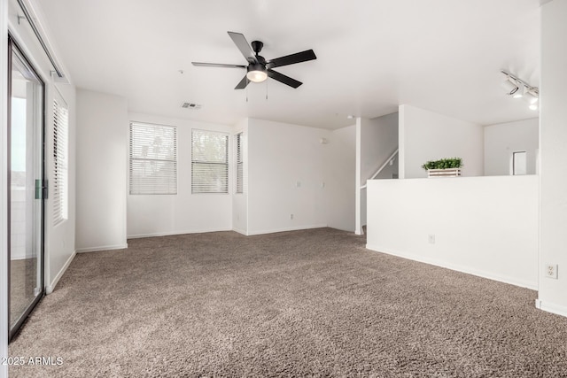 unfurnished living room with baseboards, visible vents, ceiling fan, track lighting, and carpet flooring