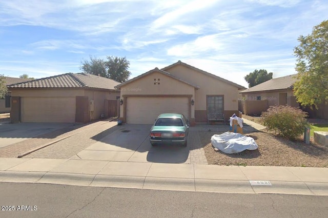 single story home featuring a garage, stucco siding, and driveway