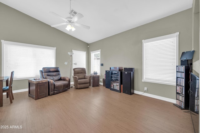 living area with ceiling fan, baseboards, lofted ceiling, and light wood-style floors