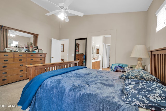 bedroom featuring ceiling fan, vaulted ceiling, ensuite bathroom, and carpet