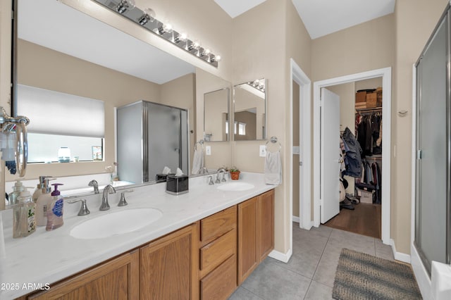bathroom featuring double vanity, tile patterned floors, a sink, and a stall shower