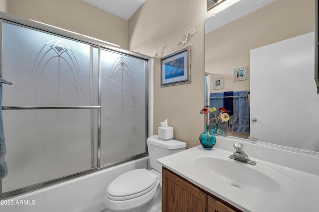 full bathroom with toilet, a textured wall, bath / shower combo with glass door, and vanity