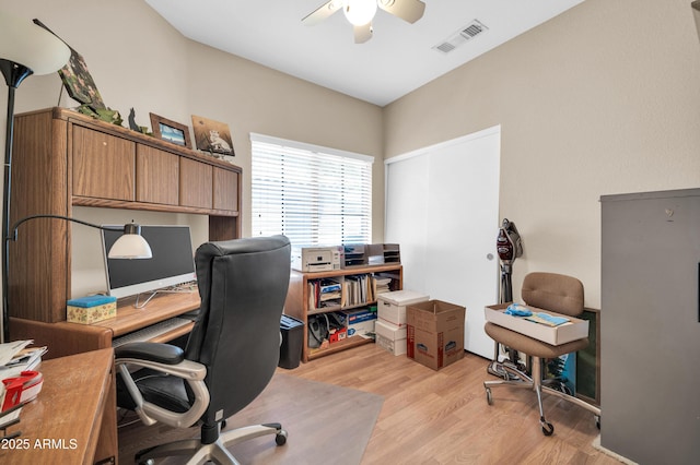 home office featuring ceiling fan, light wood-style flooring, and visible vents