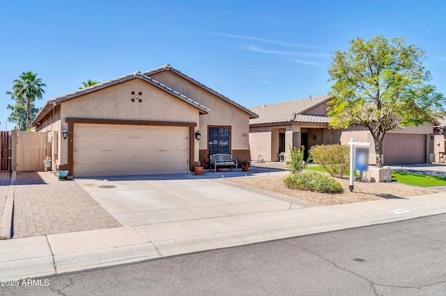 single story home featuring a garage, stucco siding, concrete driveway, and a tile roof