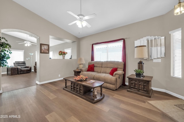 living room featuring a ceiling fan, vaulted ceiling, a healthy amount of sunlight, and wood finished floors