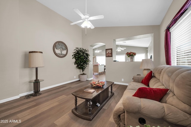 living area with arched walkways, high vaulted ceiling, a ceiling fan, baseboards, and wood finished floors
