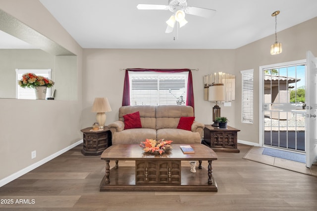 living room featuring baseboards, ceiling fan, and wood finished floors