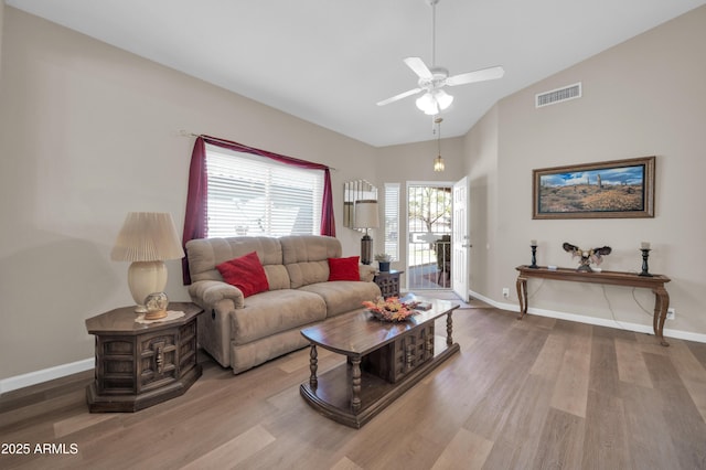 living room with visible vents, wood finished floors, baseboards, ceiling fan, and high vaulted ceiling