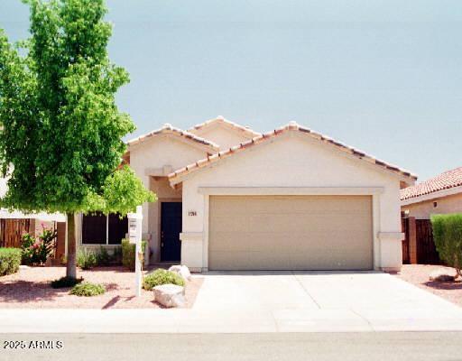 12205 N 41st Ln, Phoenix, AZ 85029 - mediterranean / spanish-style house featuring a garage, stucco siding, driveway, and a tile roof