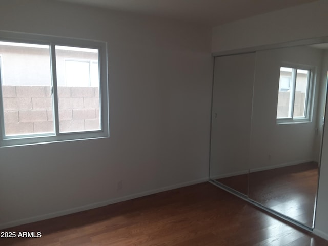 12205 N 41st Ln, Phoenix, AZ 85029 - unfurnished bedroom with dark wood-type flooring, multiple windows, and a closet