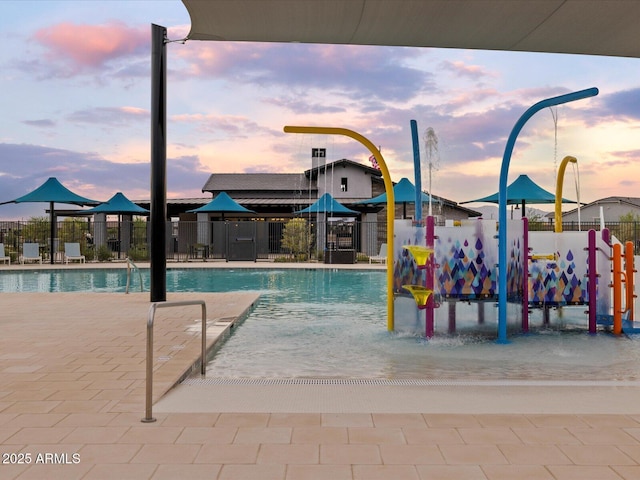 pool with a water play area and fence