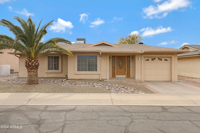 view of front of property with a garage and cooling unit