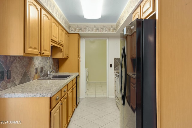 kitchen with backsplash, sink, light tile patterned floors, independent washer and dryer, and appliances with stainless steel finishes