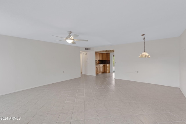 tiled empty room featuring ceiling fan