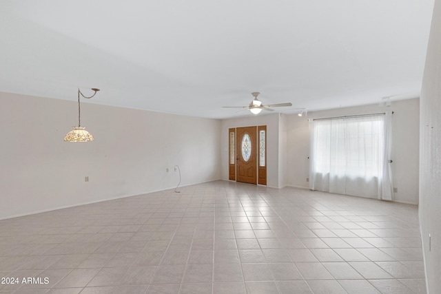 unfurnished living room featuring light tile patterned floors, a wealth of natural light, and ceiling fan