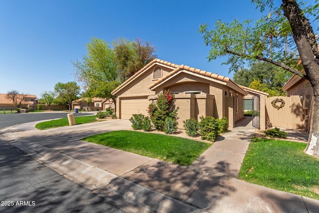 view of front of property featuring an attached garage, fence, a tile roof, stucco siding, and driveway