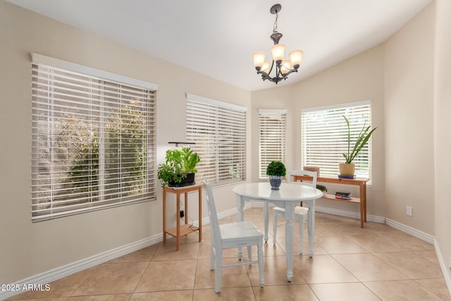 dining room featuring a notable chandelier, light tile patterned floors, baseboards, and vaulted ceiling