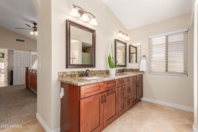 bathroom featuring lofted ceiling, double vanity, visible vents, and a sink