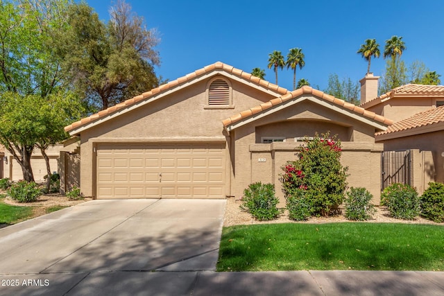 view of front of house with a tiled roof, stucco siding, driveway, and a garage