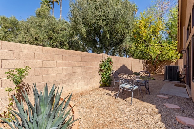 view of yard featuring cooling unit, a fenced backyard, and a patio area