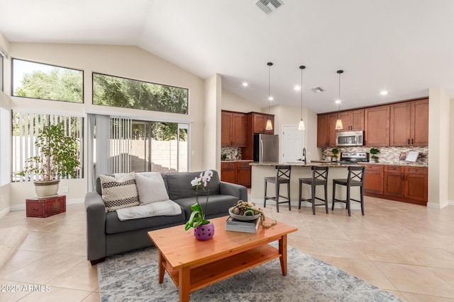 living room with light tile patterned floors, visible vents, and high vaulted ceiling