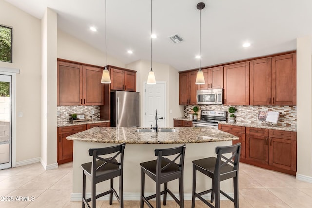 kitchen featuring visible vents, a sink, stainless steel appliances, a breakfast bar area, and light tile patterned floors