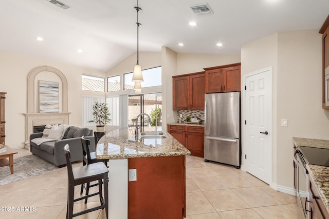 kitchen with visible vents, light tile patterned flooring, freestanding refrigerator, a sink, and electric stove