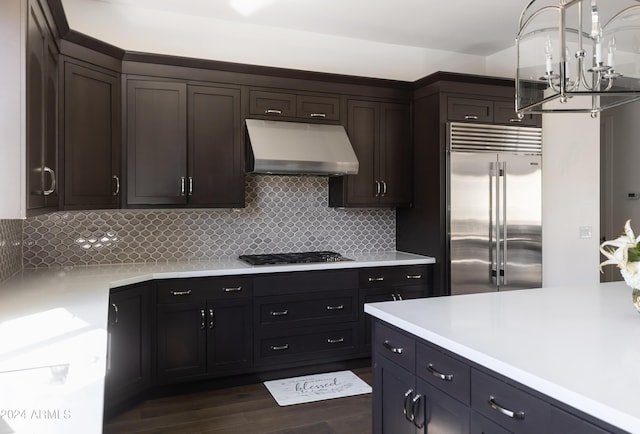 kitchen featuring decorative backsplash, dark hardwood / wood-style floors, dark brown cabinetry, and appliances with stainless steel finishes